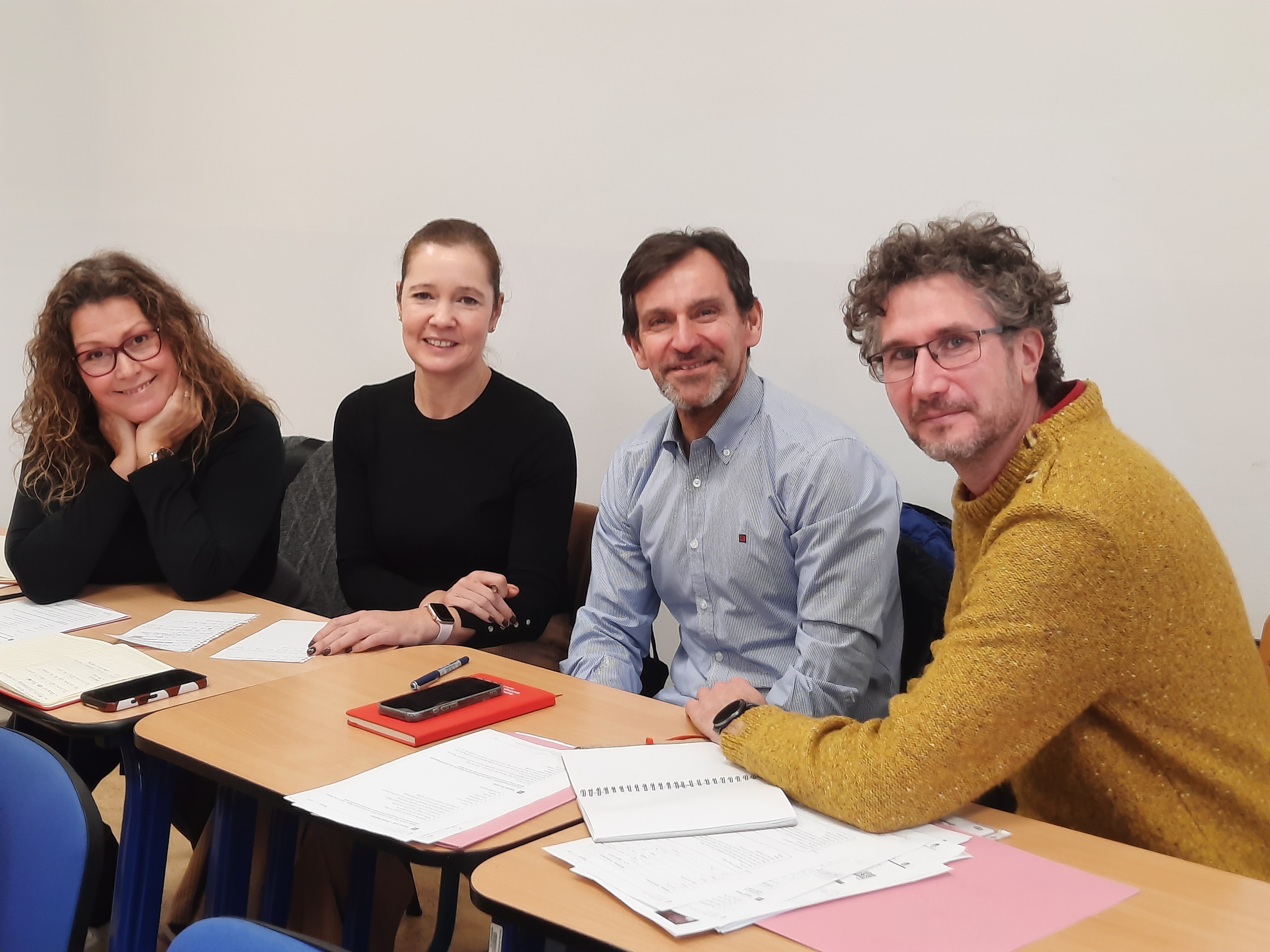 Students in a language course sitting together at a table.
